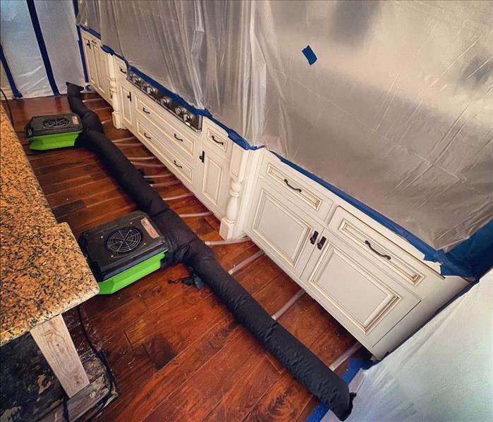 SERVPRO cavity drying equipment in front of kitchen cabinets and appliances