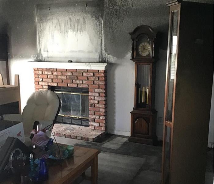 Fireplace in a living room with smoke damage and fire extinguisher residues on walls